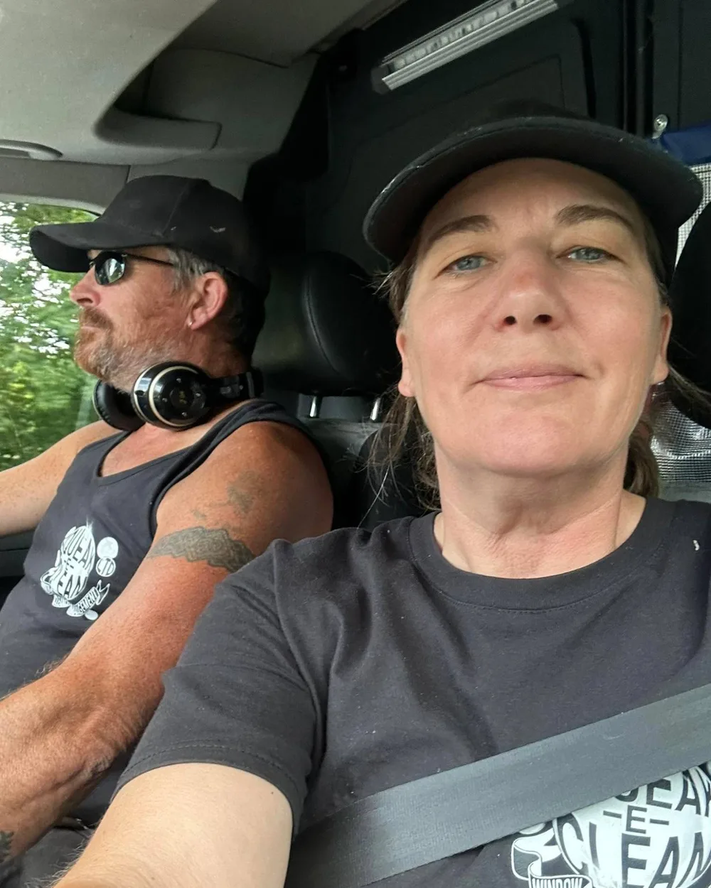 Nick and Hayley in the Squeak-E-Clean van, both in branded black T-shirts and caps