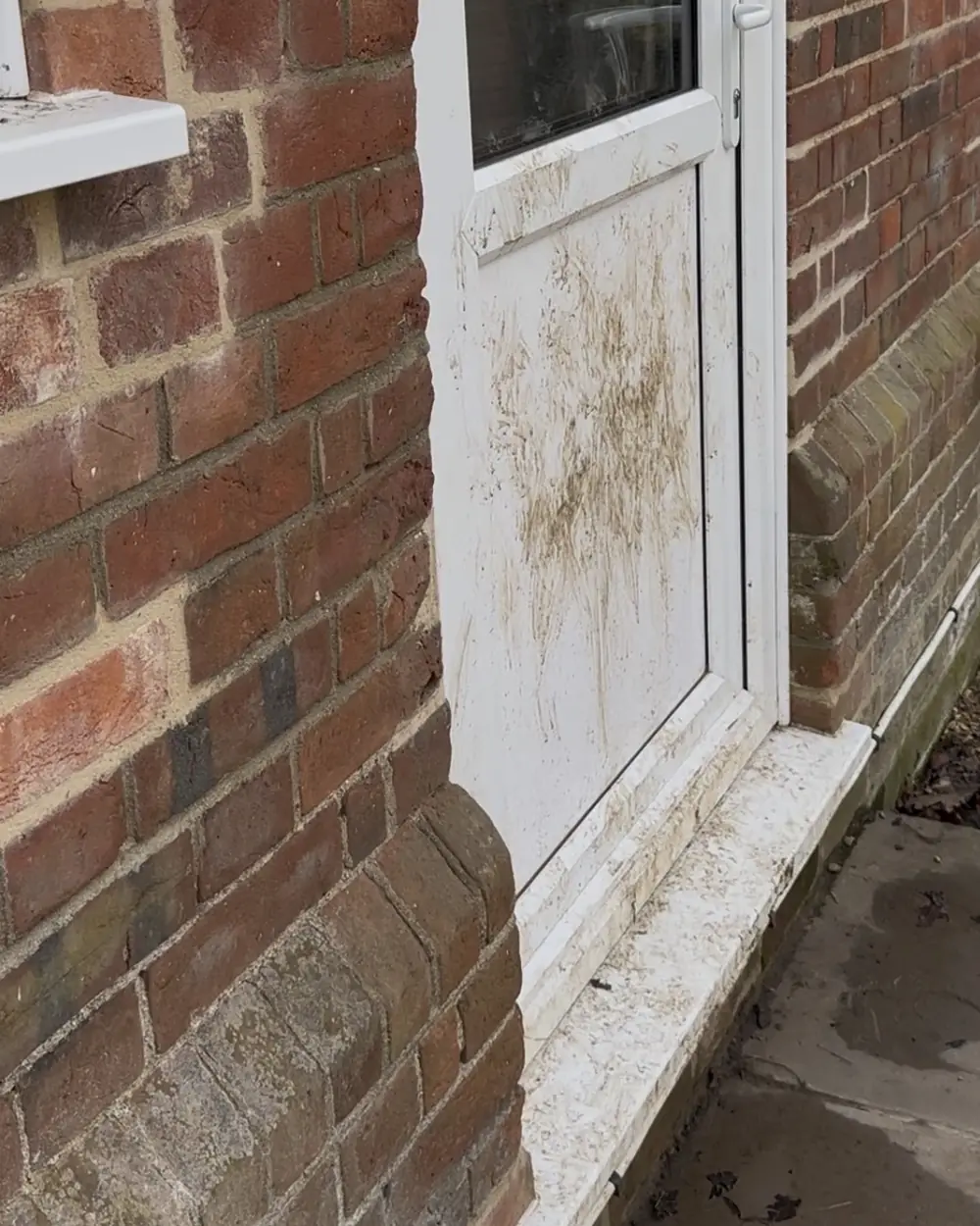 Before: a white uPVC back door splashed with mud at the bottom