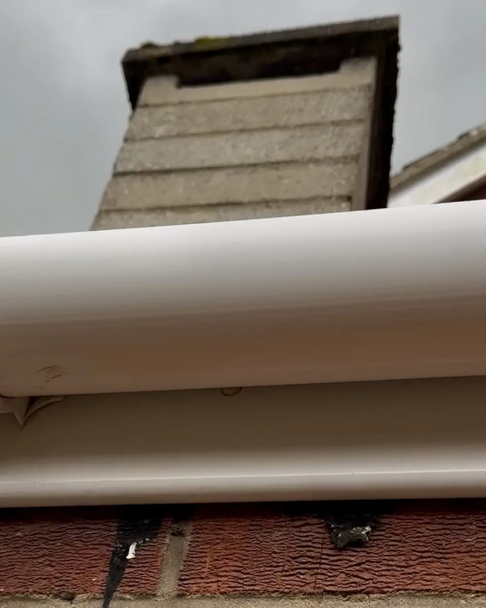 After: the same gutter and fascia washed back to white