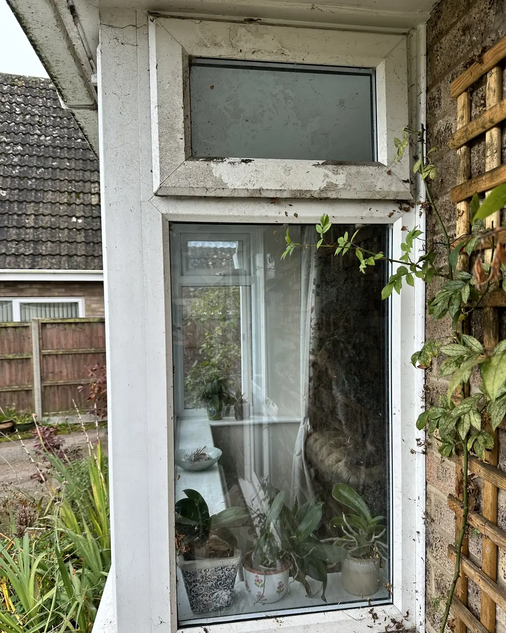 Before: a white uPVC window with a top light, its frames and sill grey with dirt