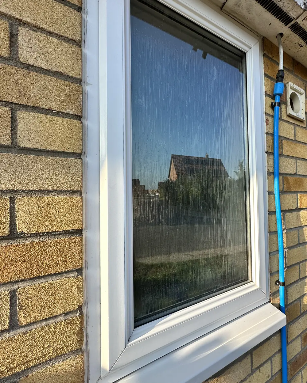 After: the same window with clear glass and a clean white sill